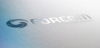 Ein Foto von dem Logo von Forcam, das auf einer grauen Oberfläche eingestanzt ist.s