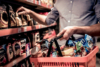 Person shopping in a supermarket, holding a basket filled with packaged food items.