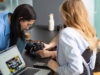 zwei junge Frauen beim Auswerten von Fotos auf einer Kamera