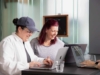 zwei Frauen am gemeinsamen Arbeiten an Laptops mit guter Laune