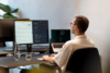 Ein Webentwickler schreibt sauberen Code an einem Multi-Monitor-Setup für eine performante und skalierbare Enterprise-Website-Lösung.