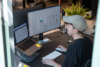 Unsere UX/UI Expertin arbeitet an einem modernen Arbeitsplatz mit zwei Monitoren an der Nutzerführung und dem Interface-Design einer digitalen Marke.